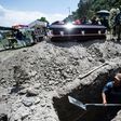 A grave is dug while a family waits during a funeral for a COVID-19 victim at the San Miguel Xico cemetery in Mexico