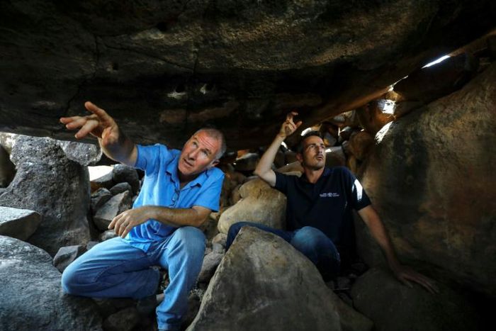 Uri Berger (R), a regional archaeologist for the Israel Antiquities Authority, and Gonen Sharon, a professor of archaeology at northern Israel's Tel-Hai college, display ancient engravings inside a dolmen