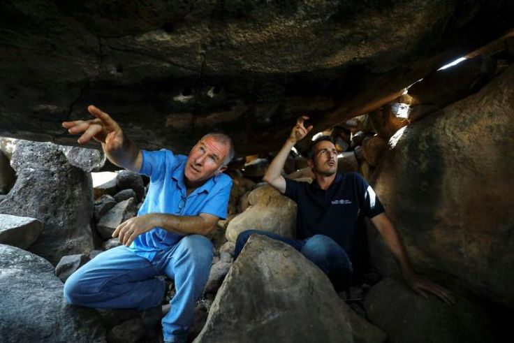 Uri Berger (R), a regional archaeologist for the Israel Antiquities Authority, and Gonen Sharon, a professor of archaeology at northern Israel's Tel-Hai college, display ancient engravings inside a dolmen