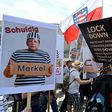 Protesters carried placards featuring German chancellor Angela Merkel as a prisoner