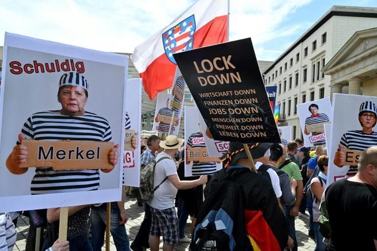Protesters carried placards featuring German chancellor Angela Merkel as a prisoner