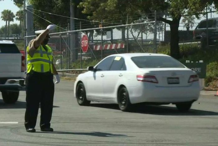 Vehicles move toward the entrance of Los Angeles' Dodger Stadium, which houses the busiest COVID-19 testing site in the United States, with about 6,500 tests administered daily