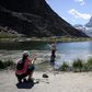 A tourist poses for a picture in the Riffelsee mountain lake with the Matterhorn mountain in background above the resort of Zermatt as heatwave sweeps across Europe
