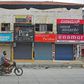 A man in a facemask rides pastshuttered shops in a commercial area  of Bangalore, India's IT hub