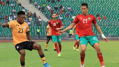 Zachariah Chilongoshi (L) of Zambia controls the ball as Soufiane Rahimi (R) of Morocco closes in during an African Nations Championship quarter-final in Douala Sunday.
