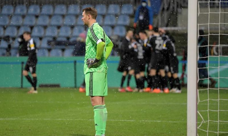 Bayern Munich goalkeeper Manuel Neuer (L) looks on as Kiel's players celebrate during Wednesday's shock German Cup defeat