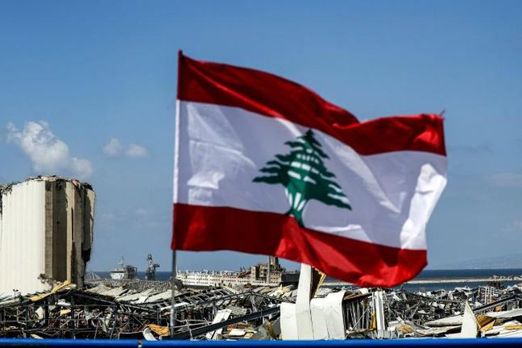 A Lebanese flag flies on a bridge near the port of Lebanon's capital Beirut, amid the destruction of Tuesday's explosion that killed over 150