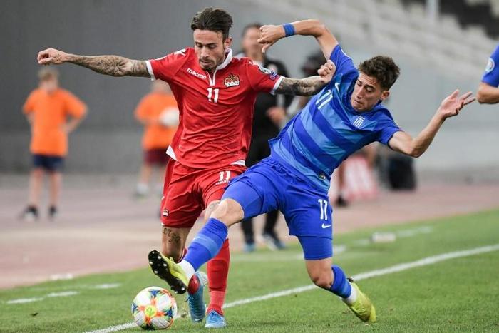 Liverpool have signed Greece left-back Kostas Tsimikas (R) from Olympiakos