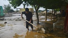 A resident clears mud in Charikar after flash floods killed nearly 50 people