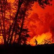 A firefighter douses flames as they push towards homes during the Creek Fire in the Cascadel Woods area of unincorporated Madera County, California on September 7, 2020