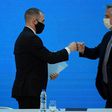 Argentina's President Alberto Fernandez (R) and Economy Minister Martin Guzman greet each other with a fist bump after announcing the restructuring of a $66 billion foreign-law debt