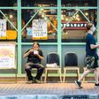 A man eats a takeaway meal outside a restaurant in Sham Shui Po, Hong Kong, after the dine-in ban was introduced