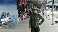 A woman wearing a face mask walks along the Tuan Chau harbour in Ha Long Bay, Vietnam