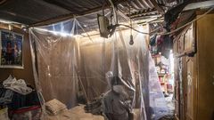 Jonathan, 30, sits on his bed behind a plastic protection as doctors make a round of visits in Ate, on the eastern outskirts of Lima