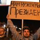 A man holds a poster reading "We need a new president" during a protest rally against police violence