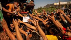 Migrants desperate to get some of the food being distributed to them two days after Greece's biggest and most notorious migrant camp, Moria, was destroyed by fire