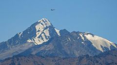 An Indian fighter flies over mountains near the border with China, where military tensions have escalated since clashes in June