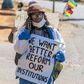 Zimbabwean novelist Tsitsi Dangarembga holds a placard during an anti-corruption march along Borrowdale road, in Harare; she was arrested and freed on bail the following day