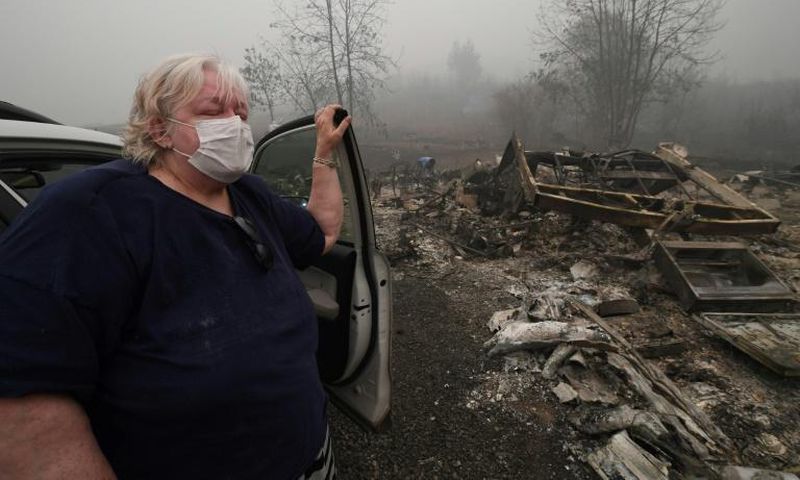 Margi Wyatt stands in front of her incinerated mobile home