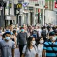 People, wearing a face mask, walk in the Kalverstraat, in Amsterdam on August 5, 2020, from when wearing a face mask is mandatory in five usually crowded places in the city of Amsterdam