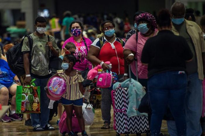 People prepare to board a bus in Lake Charles, Louisiana for evacuation before the arrival of Hurricane Laura