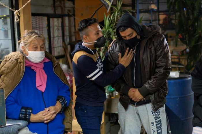 Jose Perez (R) and his mother Teresa Lazcano Alducin (L) mourn Adriana and Guadalupe Perez Lazcano, sisters of Jose, who died from COVID-19