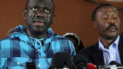 Opposition leader Kizza Besigye, left, speaking to the press after being bailed on treason charges in July 2016