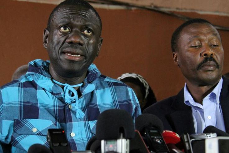 Opposition leader Kizza Besigye, left, speaking to the press after being bailed on treason charges in July 2016