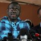 Opposition leader Kizza Besigye, left, speaking to the press after being bailed on treason charges in July 2016