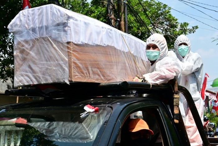 Officials in hazmat suits paraded empty coffins through the streets of Jakarta to remind residents that coronavirus cases are still surging