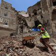 Yemeni labourers remove rubble ahead of restoration works on the site of a collapsed UNESCO-listed building following heavy rains in the Old City of the Yemeni capital Sanaa