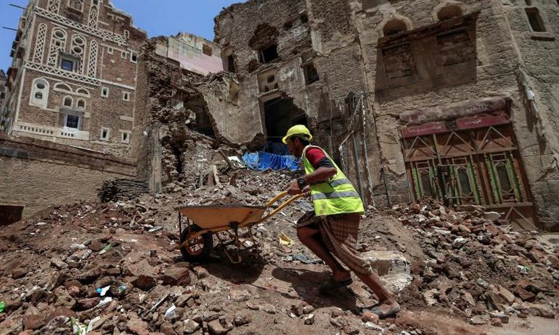 Yemeni labourers remove rubble ahead of restoration works on the site of a collapsed UNESCO-listed building following heavy rains in the Old City of the Yemeni capital Sanaa