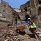 Yemeni labourers remove rubble ahead of restoration works on the site of a collapsed UNESCO-listed building following heavy rains in the Old City of the Yemeni capital Sanaa