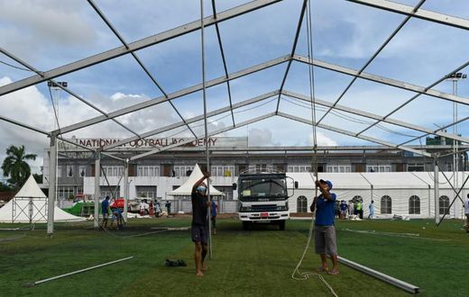 Workers building temporary shelters for coronavirus patients on a football pitch in Yangon, where new infections have spiked prompting opposition parties to call for a postponement of elections due in November