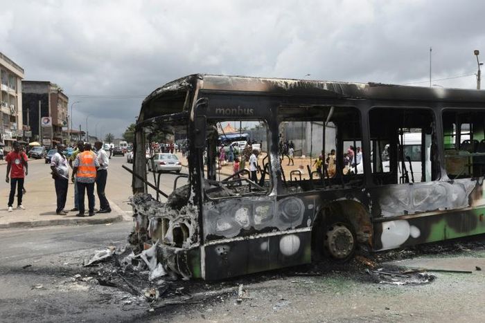Protesters torched a bus in a working-class district of Abidjan