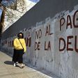 A woman passes by a wall reading "No to the Debt Payment" in Buenos Aires, on August 3, 2020 -- the day before a deal was reached on restructuring of $66 billion of debt
