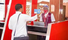 A traveller presents their travel documents to a Bluebird Aviation attendant