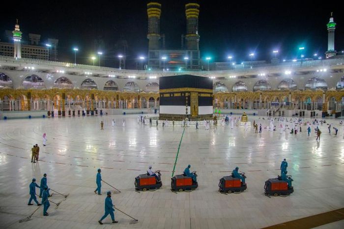 A handout picture from the Saudi Ministry of Media shows workers cleaning while some pilgrims pray in front of the Kaaba, Islam's holiest shrine, at the Grand Mosque complex in Saudi Arabia's holy city of Mecca during the annual hajj pilgrimage