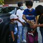 Maria, a domestic worker from Mexico, and her children receive food donations at a distribution center in Corona, Queens