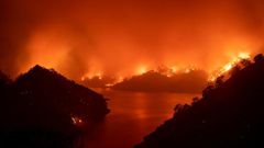 Flames surround Lake Berryessa during the LNU Lightning Complex fire in Napa, California on August 19, 2020