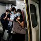 Commuters wear face masks on a metro train in Hong Kong. The city's leader says coronavirus is running "out of control" afater a daily record number of new cases