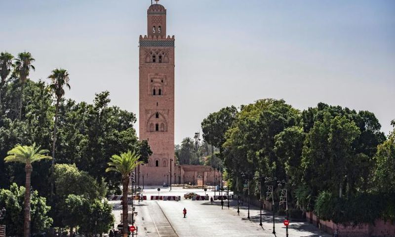 A few people walk by next to the Kutubiyya mosque's minaret tower at the Jemaa el-Fna square in the Moroccan city of Marrakesh on September 8, 2020, currently empty of its usual crowds due to the COVID-19 pandemic