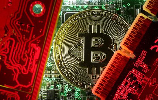 FILE PHOTO: A copy of bitcoin standing on PC motherboard is seen in this illustration picture