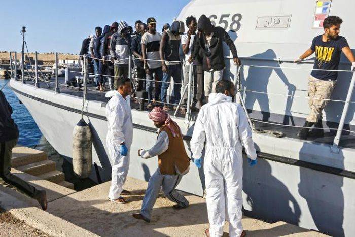 Migrants disembark in October 2019 from a Libyan coast guard ship in the town of Khoms, part of the instability that has led the United States to impose sanctions on smugglers