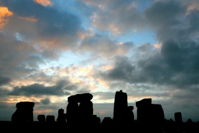 The stone circle of Stonehenge is silhouetted at sunrise during the pagan festival, Summer Solstice, in Avebury, Wiltshire, 21 June 2007
