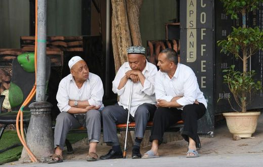 Uighur men resing in front of a coffee bar in Kashgar, western Xinjiang. China denies abusing the Uighur  population and says such accusations are slander