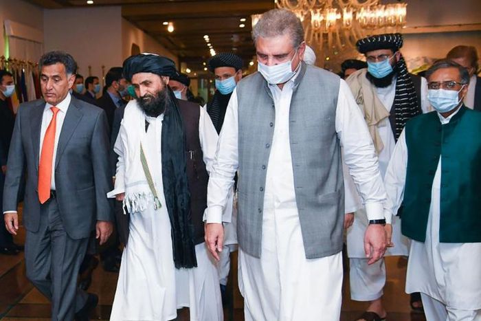 Pakistan's Foreign Minister Shah Mehmood Qureshi (third right) walks with Taliban co-founder Mullah Abdul Ghani Baradar (second left) ahead of talks in Islamabad intended to push for peace talks
