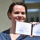 Svetlana Tikhanovskaya, the wife of a jailed vlogger running in his place, shows her certification to run for president