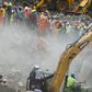Rescue workers search for survivors in the rubble of the collapsed five-storey apartment building in Mahad