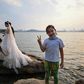 A girl gestures while a couple poses for a wedding photographer next to East Lake in Wuhan
